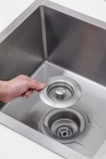 Two brushed stainless steel kitchen sink drain stoppers with pop-up strainers, shown from a top-down angle.