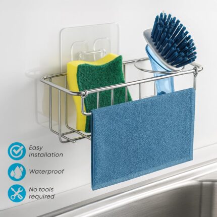 Silver KESOL stainless steel sink caddy holding two yellow sponges, a dish brush, and a folded dishcloth inside a kitchen sin