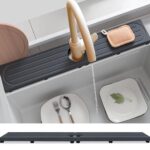 Dark gray diatomite stone faucet mat with a rectangular shape, placed around a kitchen sink faucet with items on it.