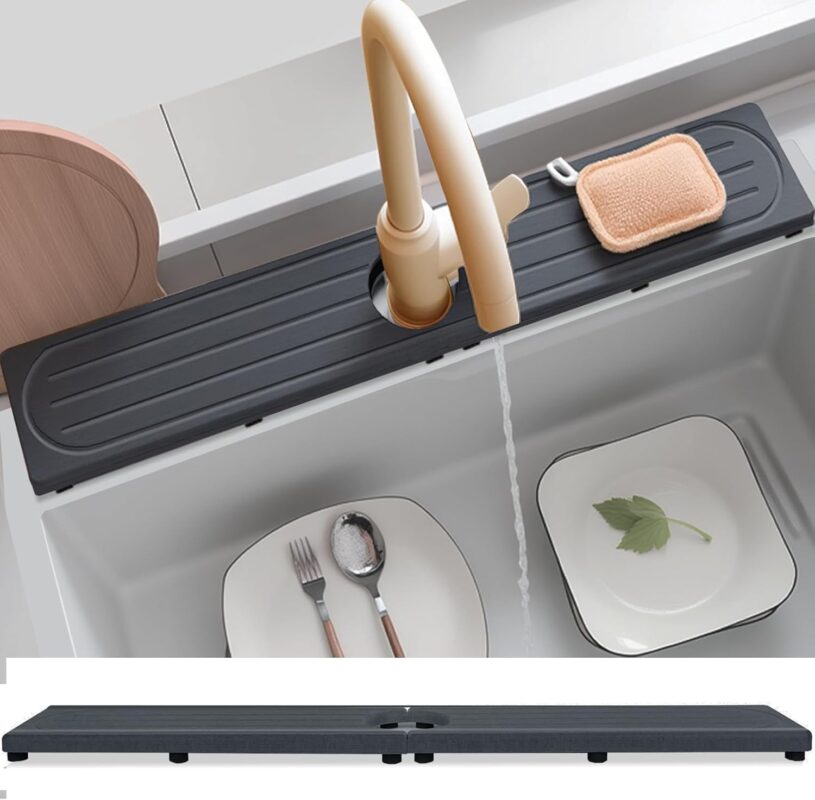 Dark gray diatomite stone faucet mat with a rectangular shape, placed around a kitchen sink faucet with items on it.