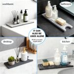 Dark gray diatomite stone faucet mat with a rectangular shape, placed around a kitchen sink faucet with items on it.