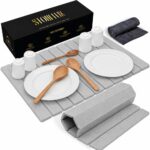 Light gray Nestive foldable diatomite stone drying mat with dishes and cups drying on a kitchen counter