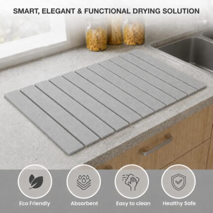 Light gray Nestive foldable diatomite stone drying mat with dishes and cups drying on a kitchen counter