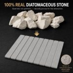 Light gray Nestive foldable diatomite stone drying mat with dishes and cups drying on a kitchen counter
