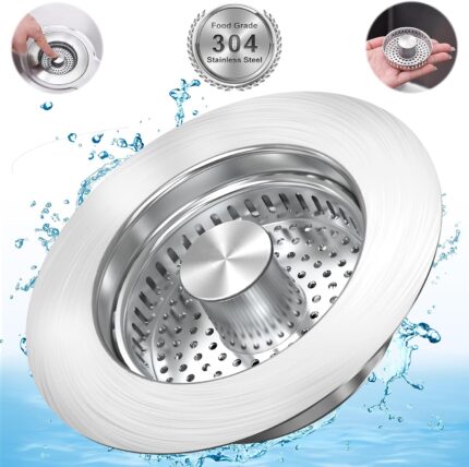 Close-up of a silver brushed stainless steel kitchen sink drain strainer with pop-up stopper in a kitchen sink.