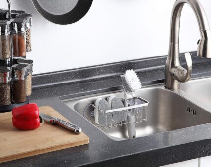 SunnyPoint NeverRust Deluxe Stainless Steel Sink Sponge Holder with an adhesive mount, shown in a clean kitchen sink.