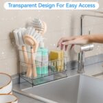 A clear plastic SuoXing sink caddy with multiple compartments holding sponges, a dish brush, and soap bottles.